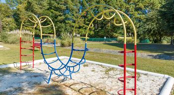 A swing set in a park with trees in the background